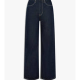 JBD High Waisted Skater Jeans feature a wide-leg silhouette in dark blue denim with front and back pockets, contrast stitching, and a classic button closure for a true 90s skater vibe.