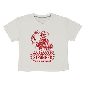 The Howdy Stranger Boxy Tee by Sendero Provisions Co. is an ultra-soft, organic cotton white t-shirt with a red cowboy skeleton graphic tipping its hat, holding a lasso, and "Howdy Stranger Sendero Provisions Co." text.