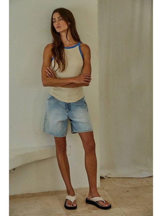 A woman stands indoors with arms crossed, wearing the By Together Knit Tank Top paired with light denim shorts and white sandals.