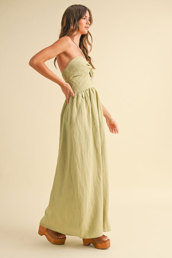 A woman in a size S Knotted Front Halter Neck Dress by Miou Muse and platform sandals stands in profile against a plain beige background.
