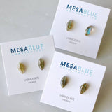 Three pairs of Labradorite Stud Earrings from Mesa Blue are shown on cards labeled "MESA BLUE HANDCRAFTED LABRADORITE intuition," each featuring stainless steel ear posts for comfort.