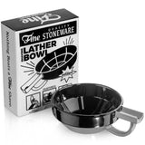 A black Lather Bowl by Fine Accoutrements with a handle sits next to its "Fine Quality Stoneware Shaving Lather Bowl" box, ideal for creating rich lather from shaving soap using your preferred shaving brush.