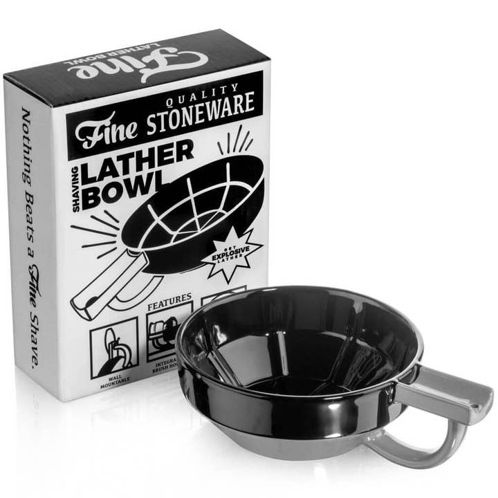 A black Lather Bowl by Fine Accoutrements with a handle sits next to its "Fine Quality Stoneware Shaving Lather Bowl" box, ideal for creating rich lather from shaving soap using your preferred shaving brush.