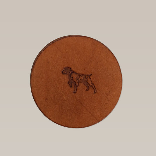The Leather Coaster 4 Piece Set by Ballad of the Bird Dog features brown leather coasters embossed with a dog profile, perfect for desk protection and pairing beautifully with a handmade leather stand.