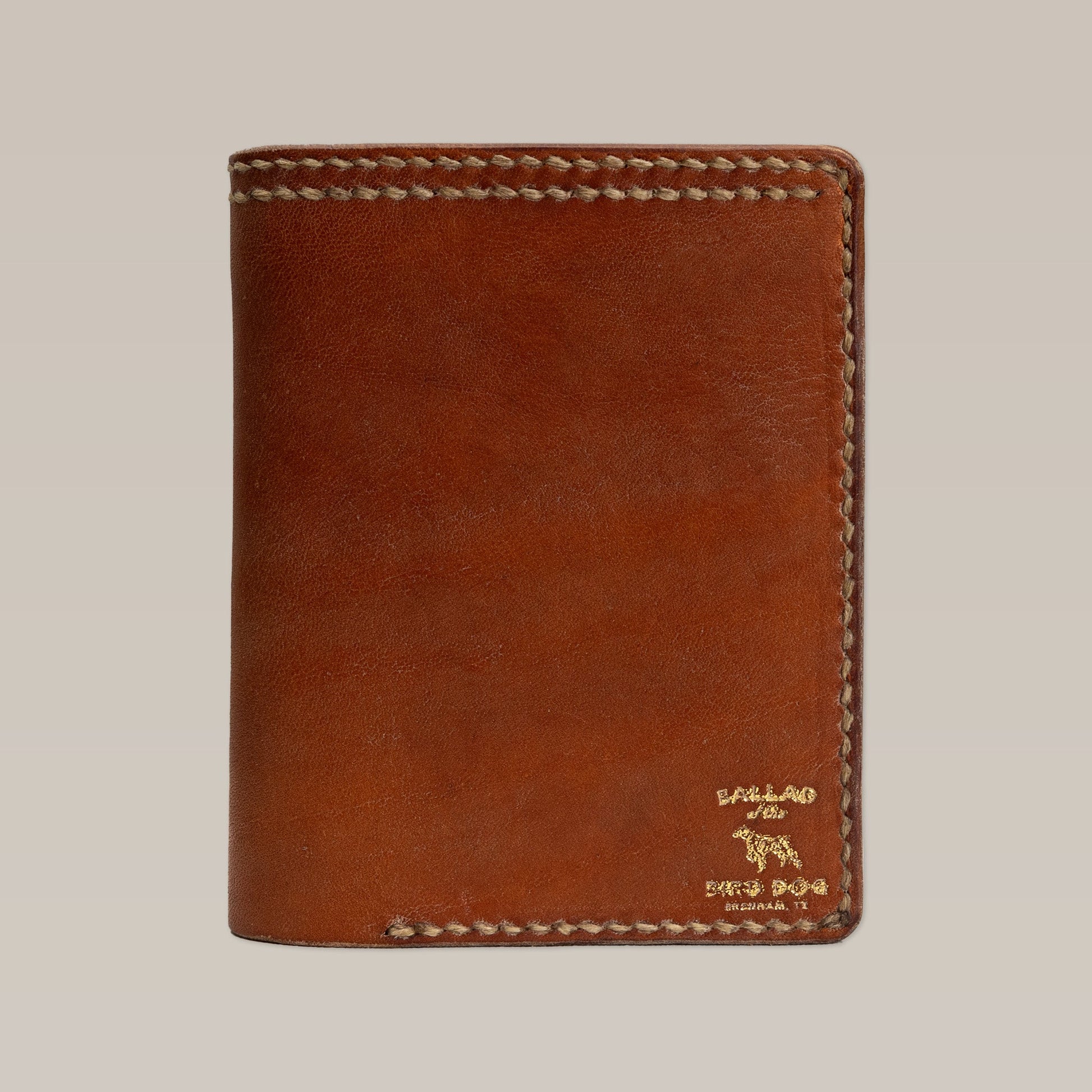 The Leather Wallet | Bi-Fold by Ballad of the Bird Dog features brown leather, visible edge stitching, and a gold embossed logo in the bottom right corner.