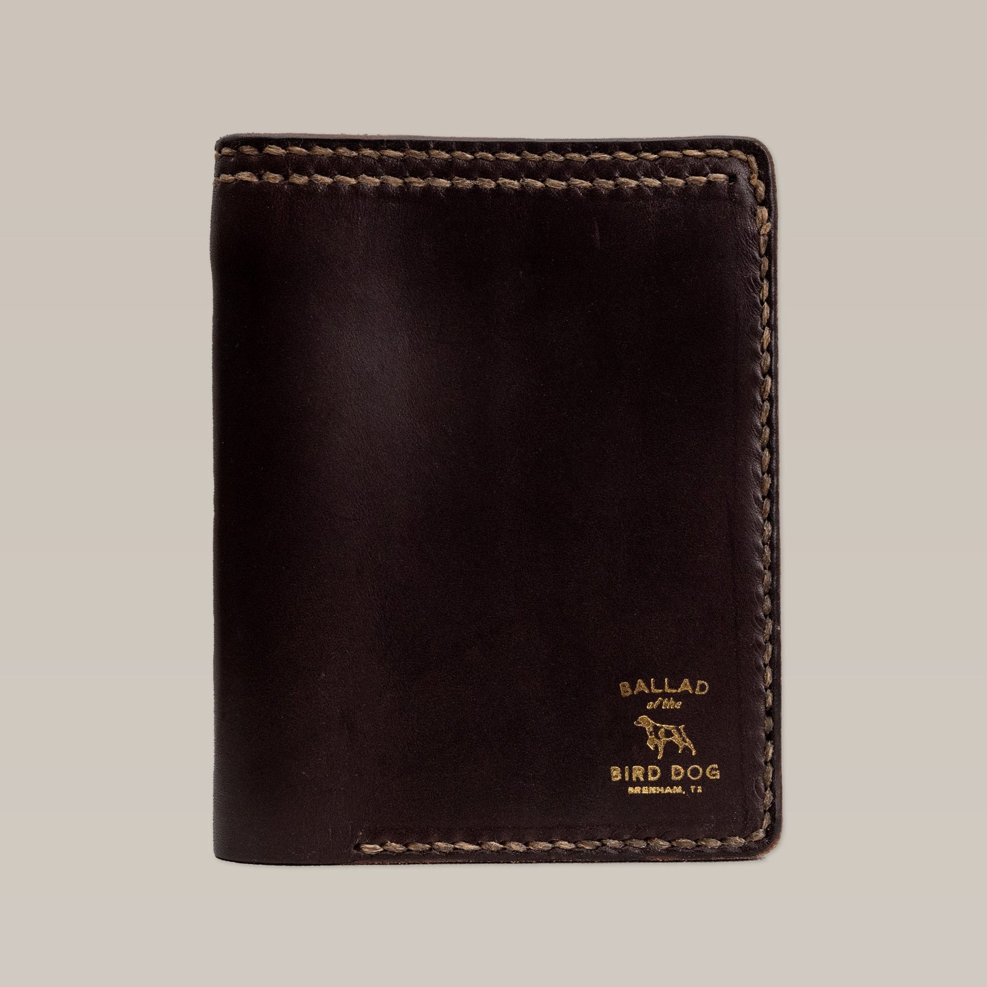 The Leather Wallet | Bi-Fold by Ballad of the Bird Dog is a dark brown leather wallet with visible stitching and a stamped "Ballad of the Bird Dog, Brenham, TX" logo in the bottom right corner.