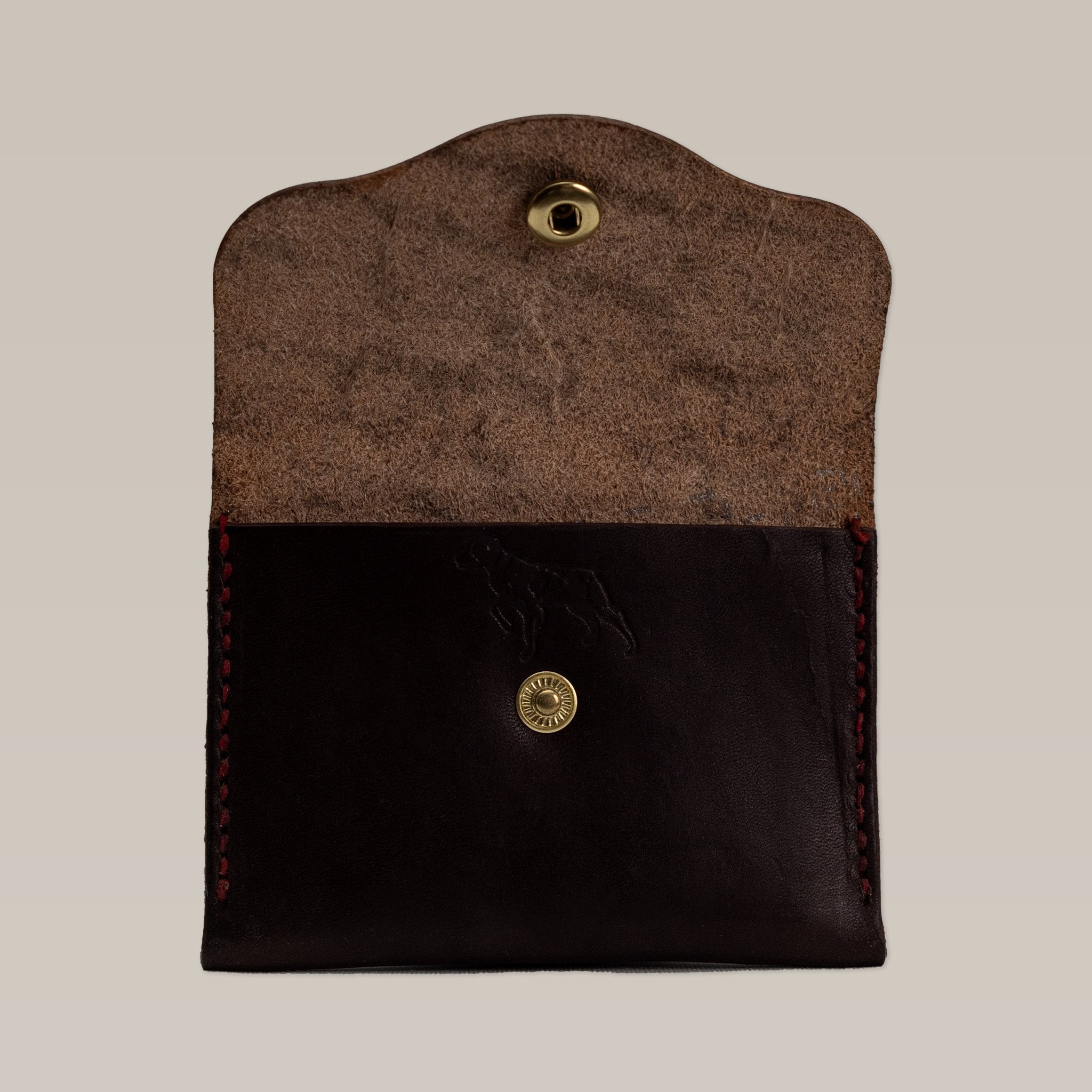 The Ballad of the Bird Dog Handcrafted Leather Wallet – Small Card Holder features an open dark brown leather design with a brass snap button and suede interior, shown against a plain background.