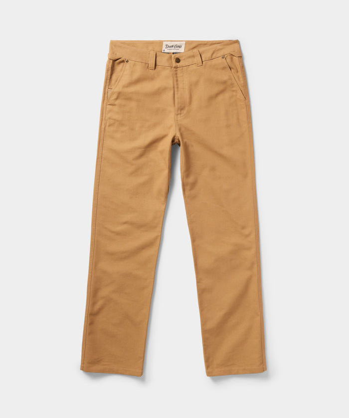 The Duck Camp Lightweight Brush Pants are tan cotton-blend pants with straight legs, belt loops, front pockets, and a button closure, shown on a white background.