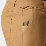 Close-up of Duck Camp Lightweight Brush Pants’ durable cotton blend pocket with a folding knife featuring an engraved handle partially tucked inside the small front pocket.