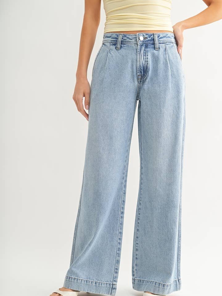 A person wearing JBD's Lightweight Drapey Relaxed Trouser in light blue and a pale yellow sleeveless top stands against a plain background.