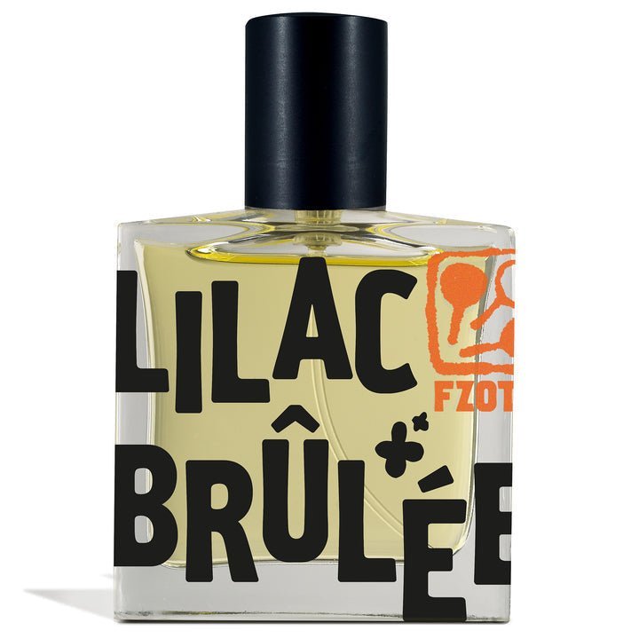 A clear glass Lilac Brulee | Fzotic perfume bottle by Fzotic features bold black "LILAC BRÛLÉE" lettering, an orange logo, a black cap, and contains pale yellow liquid with a gourmand sandalwood scent.