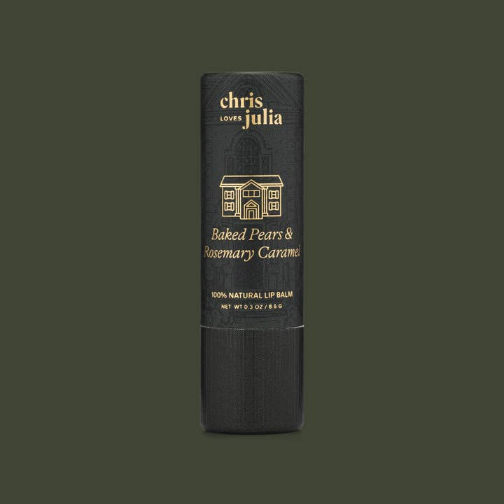 A tube of Poppy & Pout Lip Balm in Baked Pears & Rosemary Caramel flavor, 100% natural and cruelty-free, displayed against a dark green background.