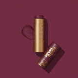 A Poppy & Pout Lip Balm in a gold tube with a matching cap labeled "poppy & pout" is featured on a burgundy background.