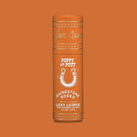 An orange cylindrical tube of Poppy & Pout Lip Balm is shown against an orange background. This handmade lip balm from Poppy & Pout is 100% natural and cruelty-free.
