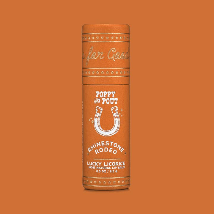 An orange cylindrical tube of Poppy & Pout Lip Balm is shown against an orange background, highlighting this hand-poured balm made with 100% natural ingredients.