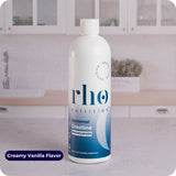 A bottle of Liposomal Creatine Monohydrate by Rho Nutrition rests on a kitchen counter, its label showing the creamy vanilla flavor and its benefits for supporting muscle performance.