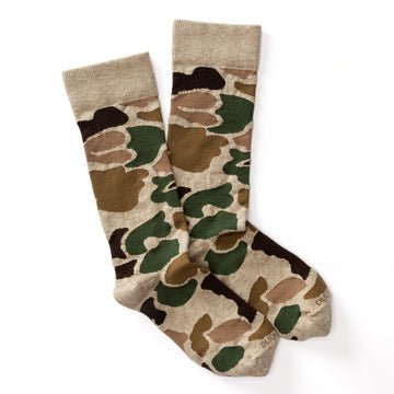 A pair of crew-length Duck Head Logo Socks featuring a beige, brown, and green camouflage pattern on a white background.