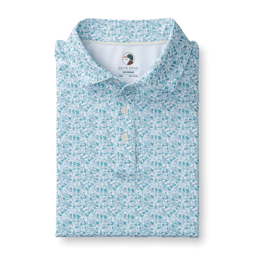 The Duck Head Long Drive Performance Polo features a light blue and white floral pattern, quick-dry, moisture-wicking fabric, and an inside collar Duck Head logo.