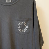 A dark gray Shop Shirt Long Sleeve | Thunderbird by Ballad of the Bird Dog featuring a chest pocket with a circle and "BALLAD OF THE BIRD DOG" printed around it.