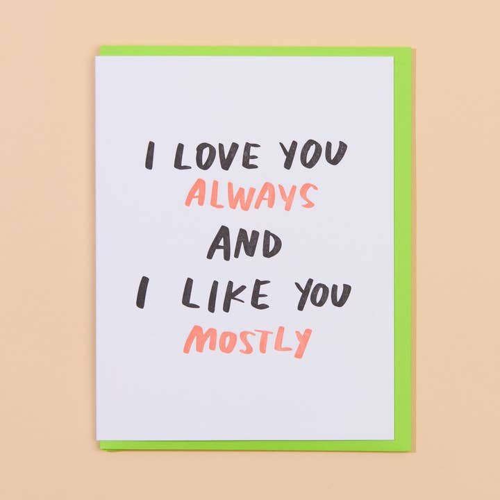 The Love you & Like you Card by And Here We Are features "I LOVE YOU ALWAYS AND I LIKE YOU MOSTLY" in bold black and red on a green envelope, making it a quirky love card for any occasion.
