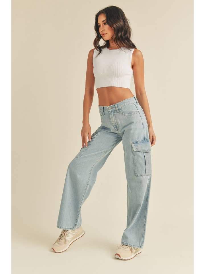 A woman poses against a plain background wearing the JBD Lt - Cargo Jean paired with a white sleeveless crop top and beige sneakers.