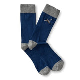 The Mallard Sock by Duck Head is a blue cotton blend pair with gray toes, heels, and cuffs, and features a small embroidered flying mallard on the side.