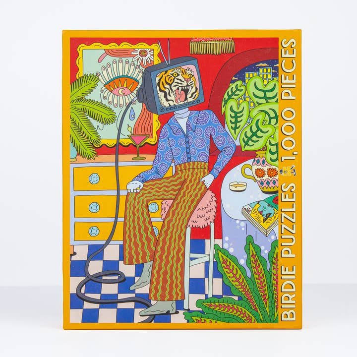 The Mama Told Me 1,000-piece puzzle by Birdie Puzzles showcases Emily M. Reay’s art—a person with a TV head amid vibrant plants and retro furniture. Made from recycled materials.