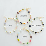 Four Mariposa Bracelets by Jill Makes—pastel, jewel tone, black & white, and bright—are arranged in a circle. Each features gemstone beads and an adjustable chain for the perfect fit.