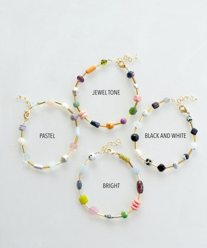 Four Mariposa Bracelets by Jill Makes—pastel, jewel tone, black & white, and bright—are arranged in a circle. Each features gemstone beads and an adjustable chain for the perfect fit.