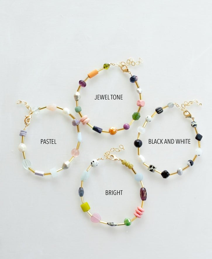 Four Mariposa Bracelets by Jill Makes—pastel, jewel tone, black & white, and bright—are arranged in a circle. Each features gemstone beads and an adjustable chain for the perfect fit.