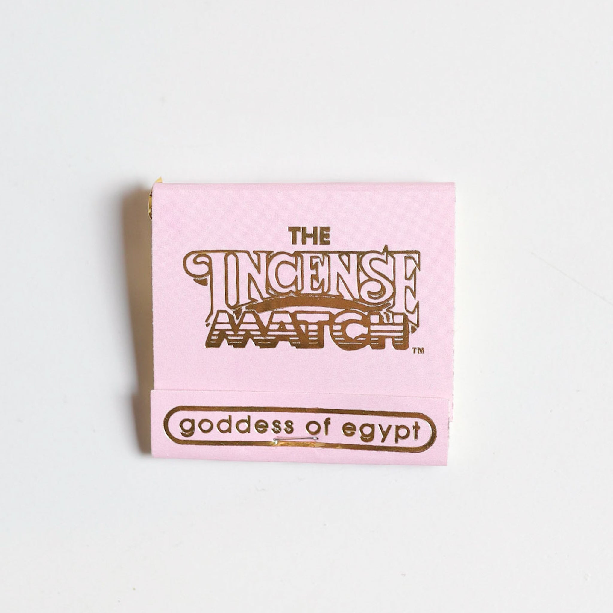 A pink booklet labeled "Matches | The Incense Match" by The Incense Match, featuring "goddess of egypt" at the bottom, is shown on a white background. This unique product works as both incense matches and an air freshener.