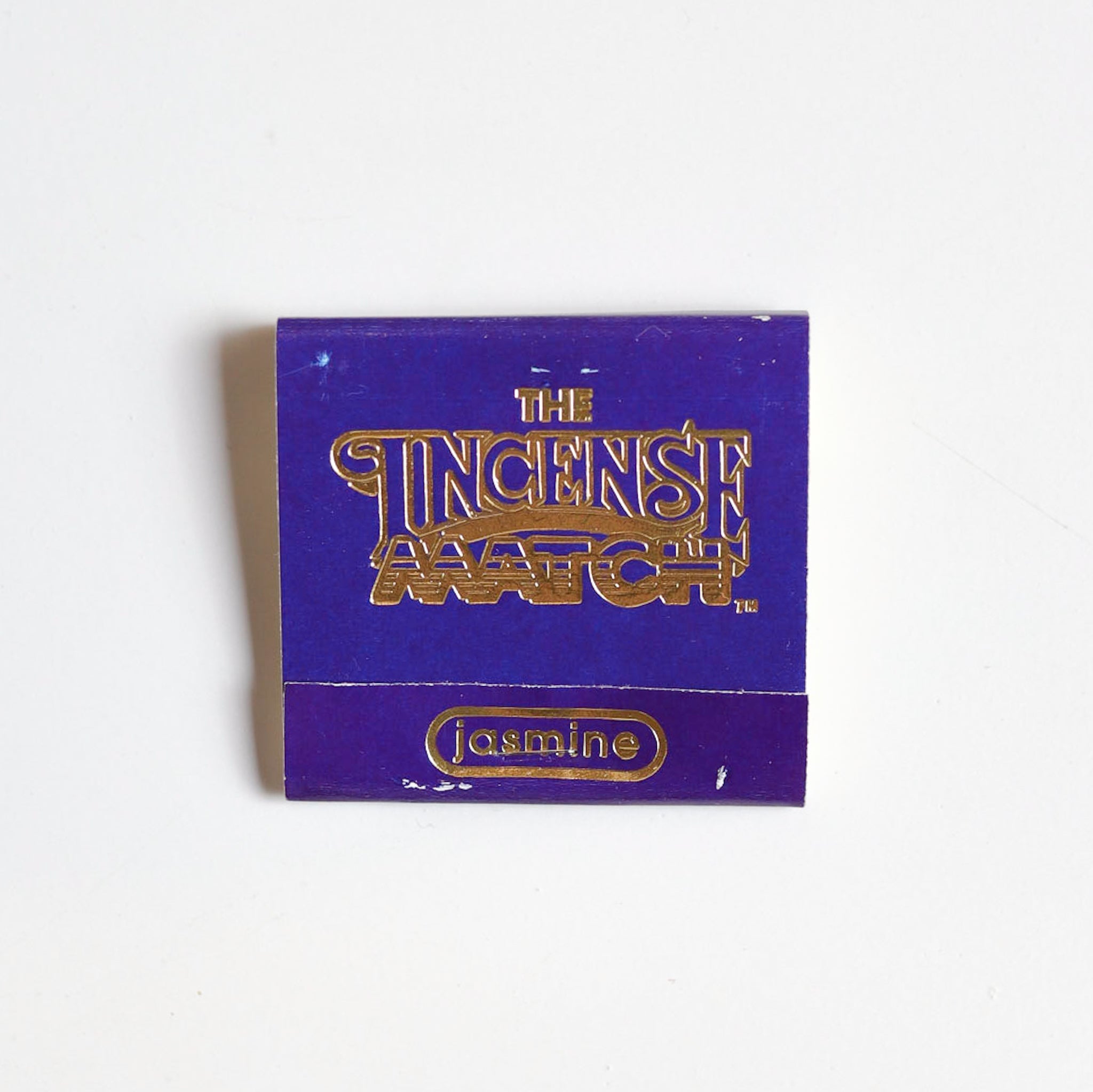 A purple booklet from The Incense Match labeled "Matches | The Incense Match" with "jasmine" in gold serves as a compact air freshener, shown on a white background.