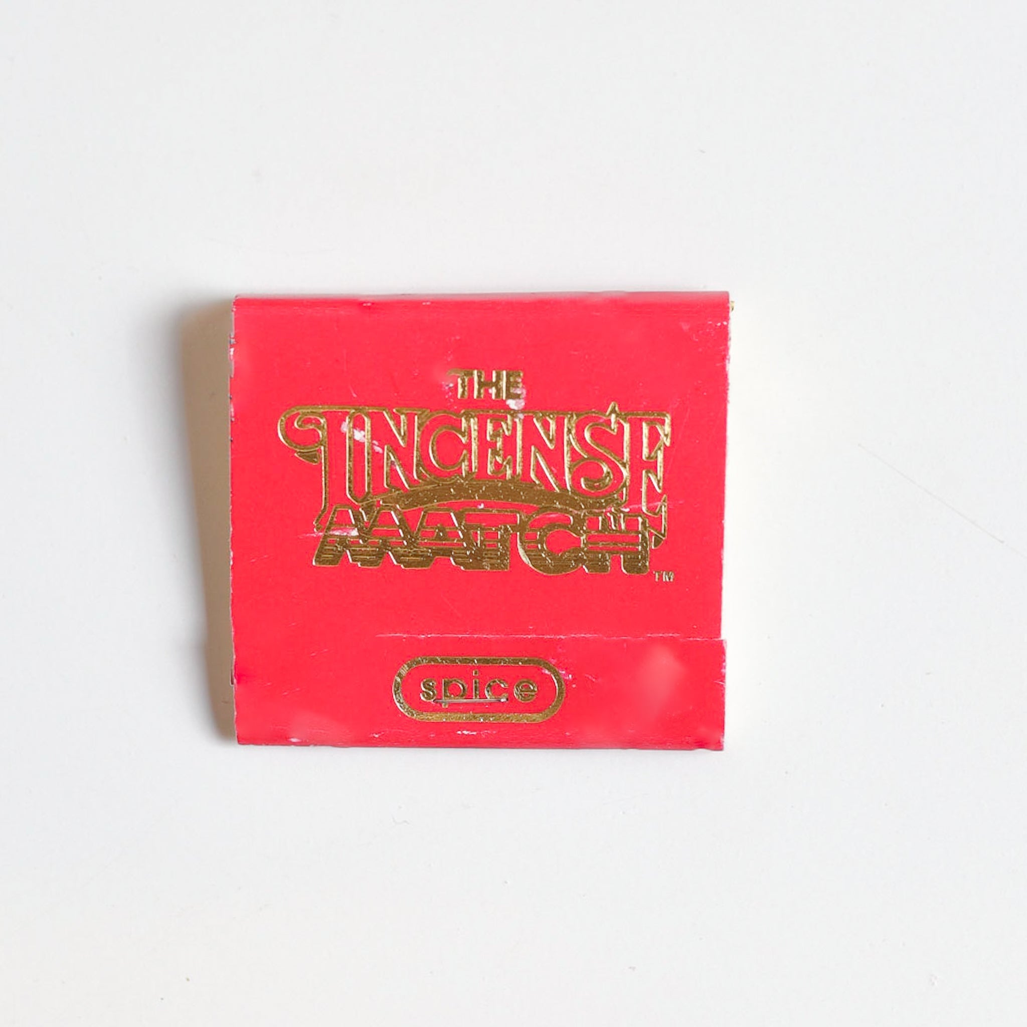 A red "Matches | The Incense Match" matchbook by The Incense Match with "Spice" in gold on the front, ideal as an incense gift or air freshener, displayed on a plain white background.