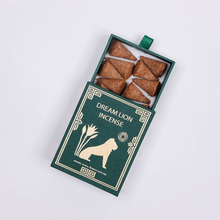 An open green box labeled "Dream Lion Incense" displays six neatly arranged brown cones of Mayan Copal + Desert Sage Incense, each crafted for purification by Dream Lion Incense.