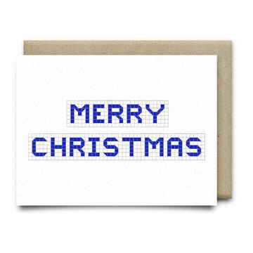 The Merry Christmas Houston Blue Tiles card by Anvil Cards is a white A2 greeting card featuring blue block "MERRY CHRISTMAS" on a grid, printed on linen paper, shown with a brown envelope. Designed in Houston, Texas.