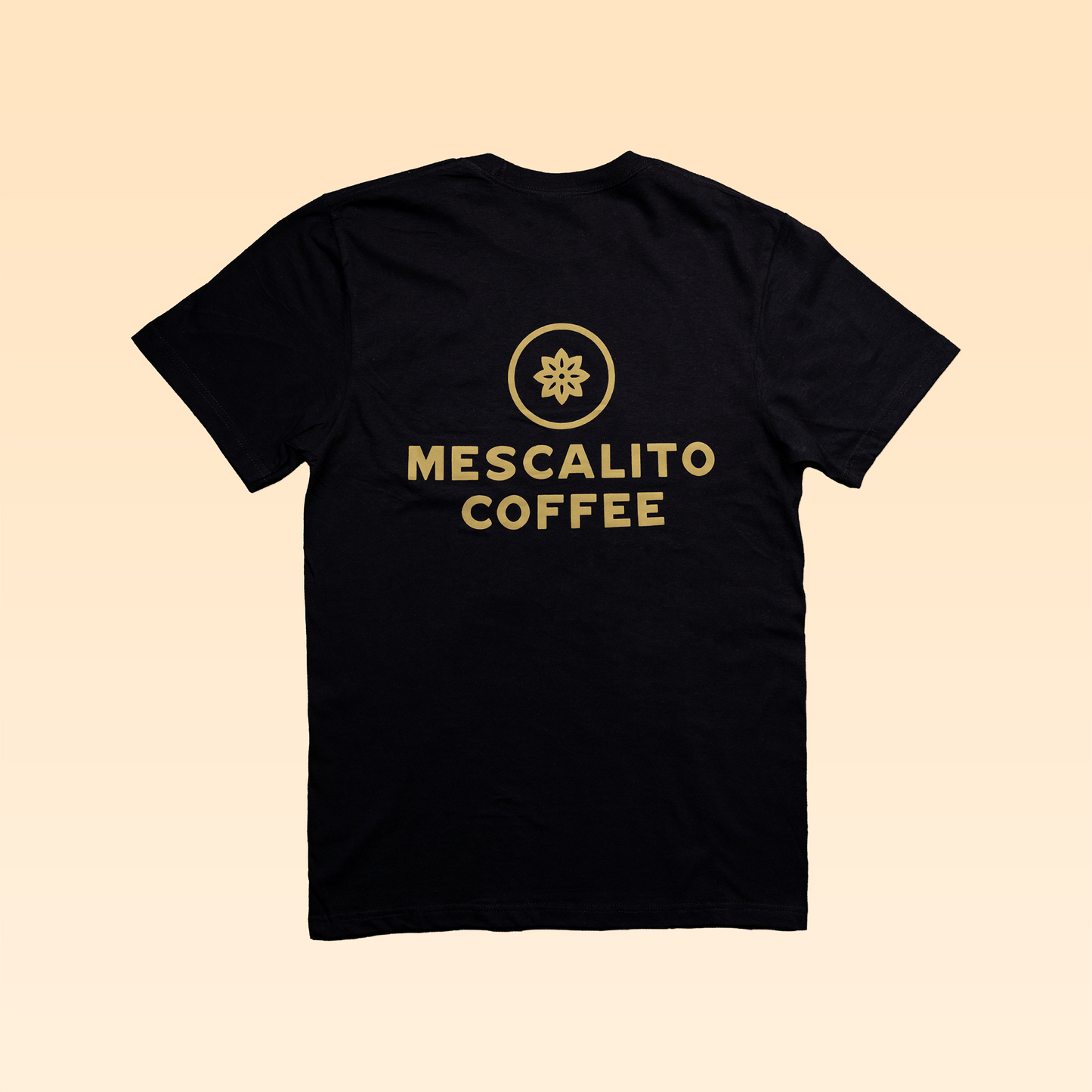 The Mescalito Coffee Shop Shirt by Mescalito Coffee features a gold circular logo and "Mescalito Coffee" on the back, inspired by Brenham’s favorite coffee shop, shown against a beige gradient background.