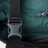Close-up of a black plastic buckle and strap on the green Mesh Gear Tote by Duck Camp, featuring a zipper and drawstring closure—perfect for securing essentials in your tote.