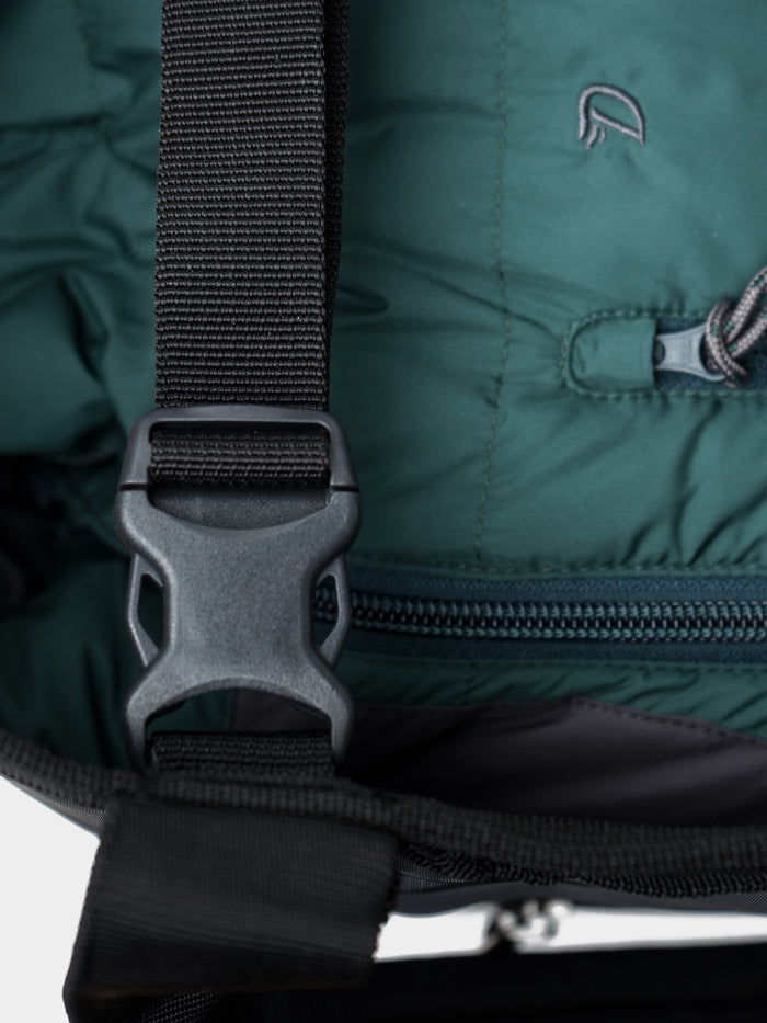 Close-up of a black plastic buckle and strap on the green Mesh Gear Tote by Duck Camp, featuring a zipper and drawstring closure—perfect for securing essentials in your tote.