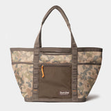 The Mesh Gear Tote by Duck Camp features a camouflage pattern, dual handles, front zip pocket with orange pull, and Duck Camp logo—perfect for carrying your essentials on any adventure.
