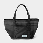 The Duck Camp Mesh Gear Tote is a black mesh bag with dual handles, an exterior zippered pocket, and a front "Duck Camp" logo patch—ideal for outdoor storage.