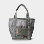 The Mesh Gear Tote by Duck Camp features a gray and camouflage design, heavy-duty build, dual handles, front zipper pocket, and a "Touch Ground" label on the lower front.