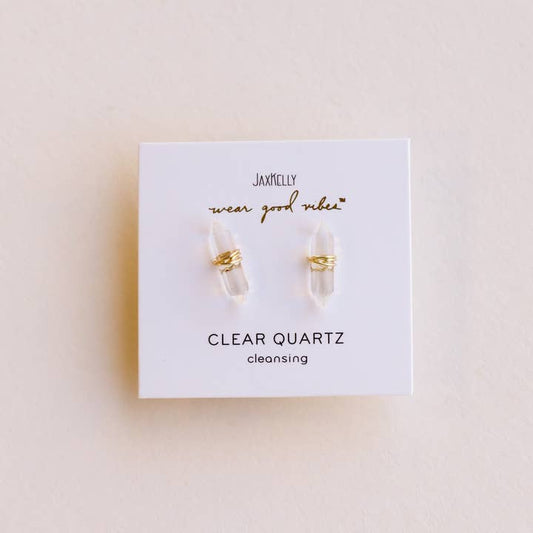A pair of hypoallergenic Mineral Point Clear Quartz earrings by JaxKelly, featuring gold wire wrapping over sterling silver, displayed on a white JaxKelly card labeled "CLEAR QUARTZ cleansing.