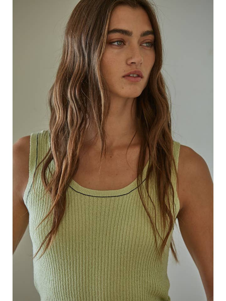 Woman with long brown hair wearing the Mira Sleeveless Top by By Together in light green, looking slightly to the side against a neutral background.