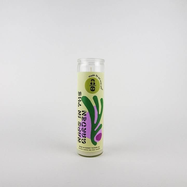 The Naps in the Garden Candle by Art Over Order is a tall glass vegan candle with a light green label, abstract purple and green shapes, and "Made in the Garden" text.