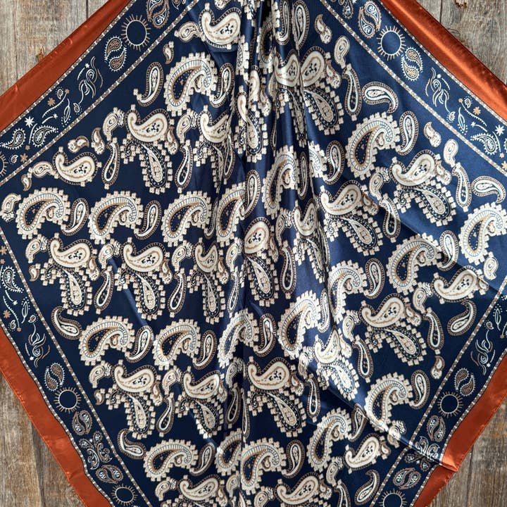 The Rodeo Drive Navy and Rust Floral Paisley Wild Rag features a stylish paisley print with a rust border—ideal as a western scarf or wild rag.