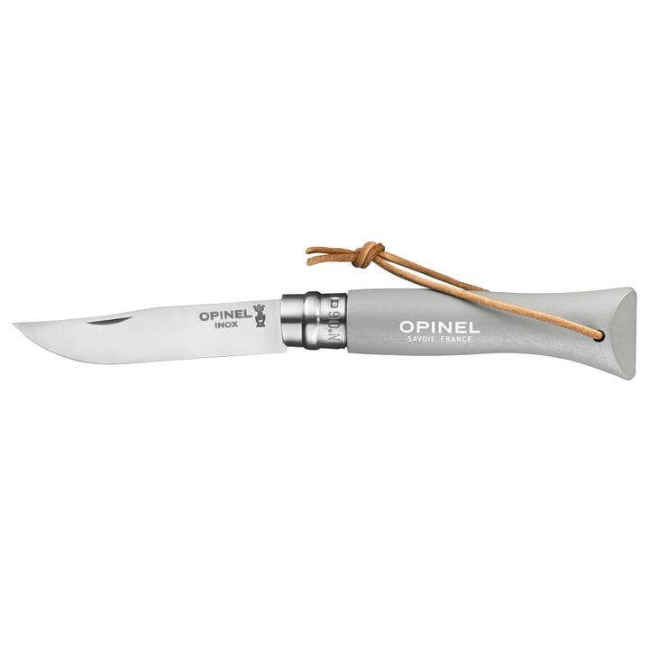 The Opinel No.06 Colorama Stainless Steel Folding Knife features a stainless steel blade, hornbeam handle, Virobloc safety ring, and a leather lanyard loop.