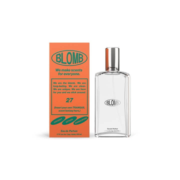 A clear bottle labeled "Blomb No. 27 Eau De Parfum" sits beside an orange box with green text highlighting fragrance notes of coconut, sweet, warmwood, and a subtle leather accord from the brand Blomb.