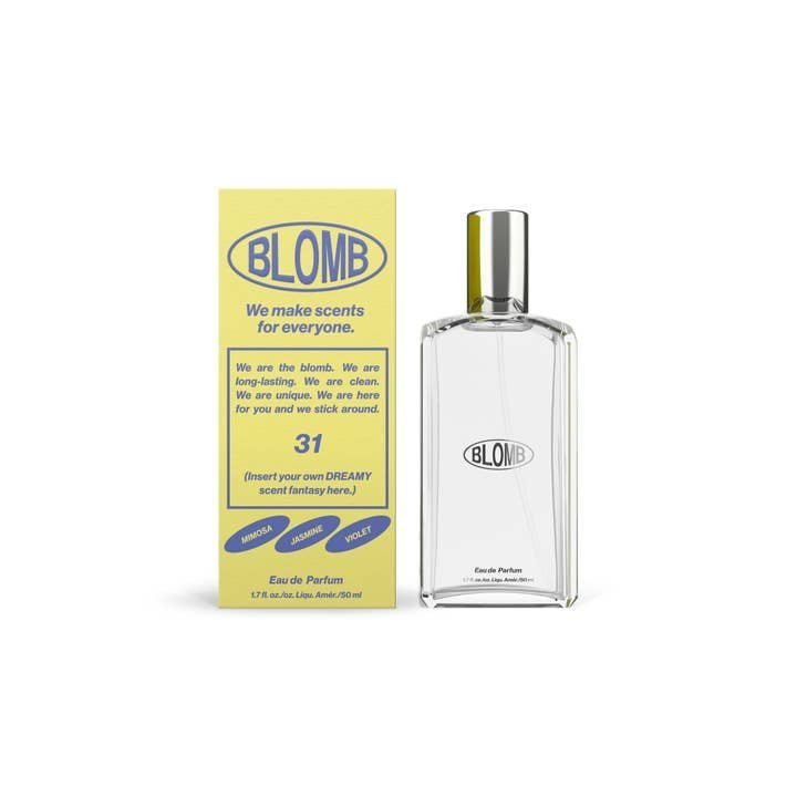 A clear glass bottle labeled "No.31 Eau De Parfum | Blomb" sits beside a yellow box with blue text featuring the Blomb brand and details about this ultra feminine fragrance.