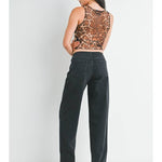 Woman standing facing away, wearing the JBD No Waistband Low Rise Straight jeans by Just Black Denim in washed black (30" inseam, straight fit), a sleeveless leopard print top, and white heeled sandals against a plain white background.