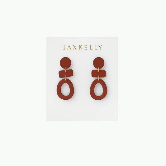The Organic Three Tier Clay Earring - Terracotta by JaxKelly features handcrafted geometric shapes in rust tones. Lightweight and eye-catching, the earrings are displayed on a white "JaxKelly" card.